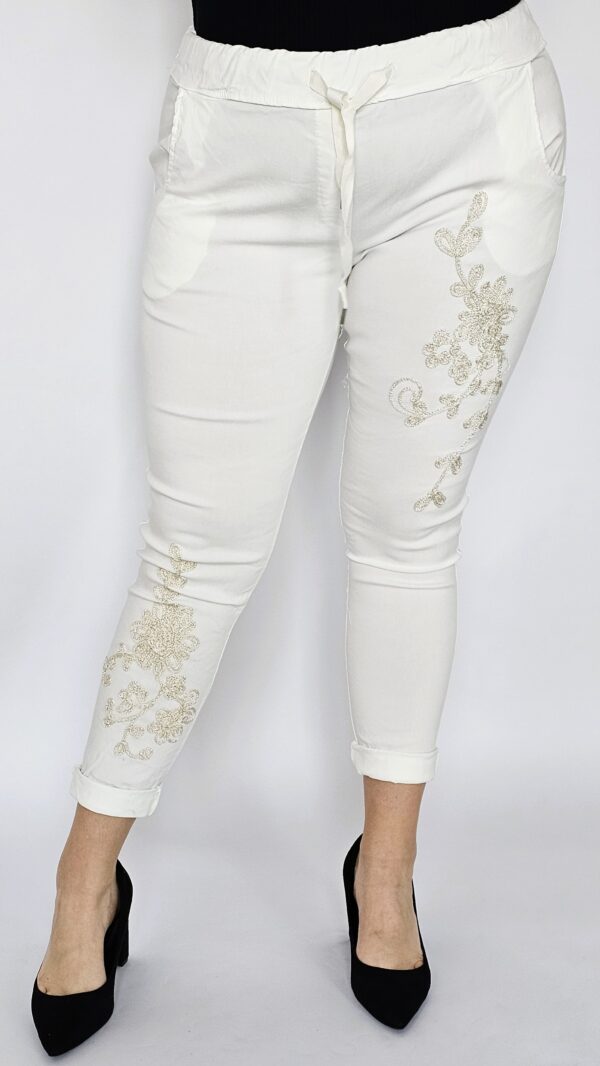 Spodnie gnieciuchy z haftowanym kwiatem na przodzie - białe